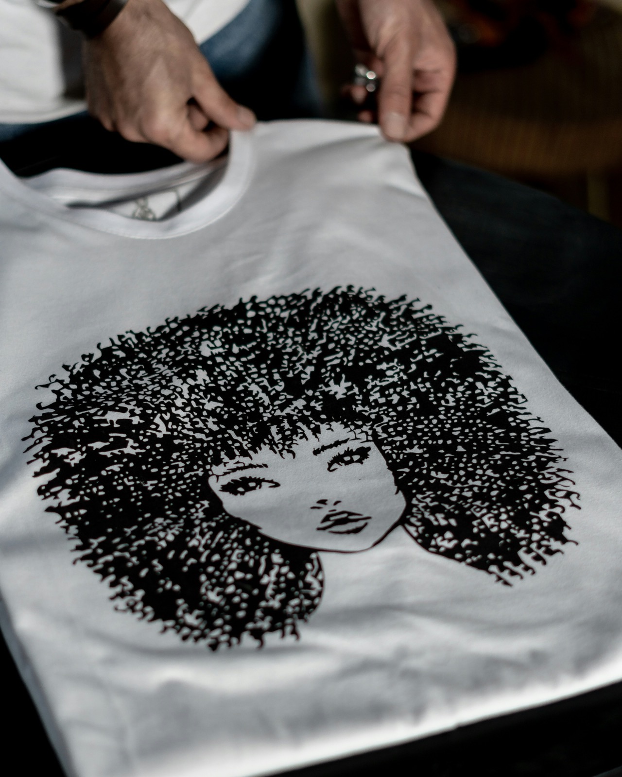 Hände halten ein frisch bedrucktes Shirt